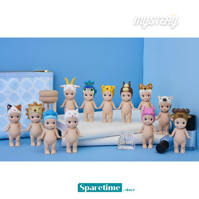 A collection of small blind-box style figurines with pale skin and animal-inspired accessories, arranged on a blue studio backdrop with a white platform. Visible items include animal-themed caps/hats and a patterned pouch.
