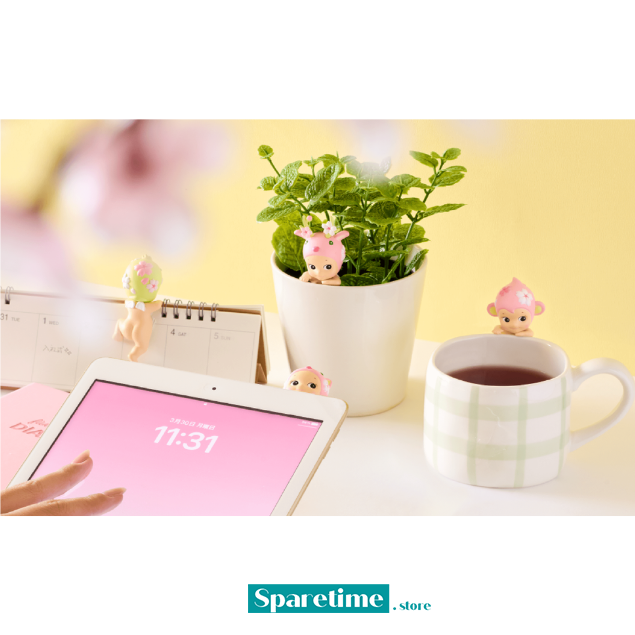 Tablet, mug with tea, plant, and small figurines on a desk with &