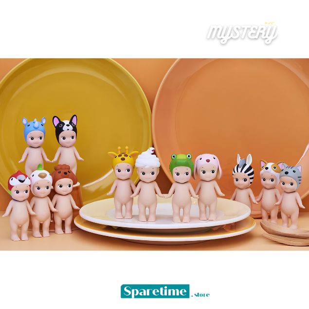 A collection of small blind-box style figurines with animal and character faces, displayed on white plates in front of large yellow and peach-colored plates. The figures have pale skin and wear colorful animal-themed hats.
