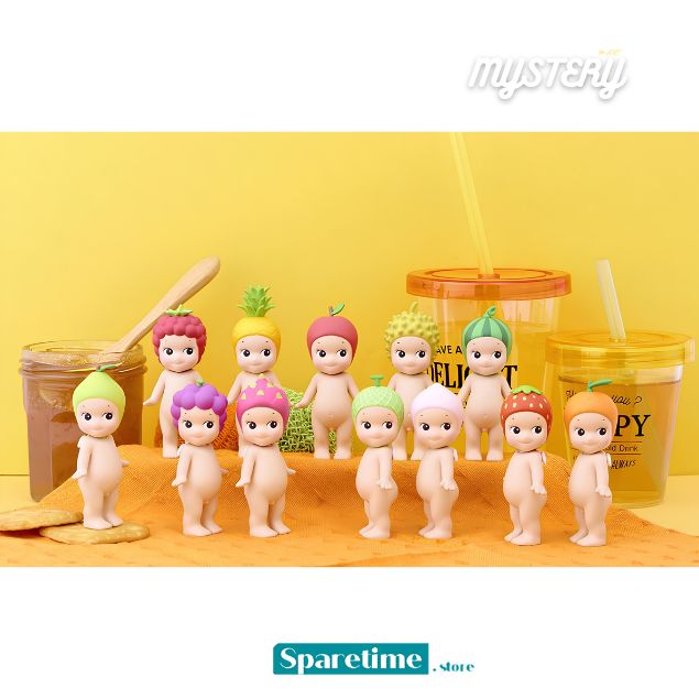 A group of small novelty figurines with colorful fruit-themed hair and hats, posed with drink cups and a jar on a yellow surface against a yellow background. The word &