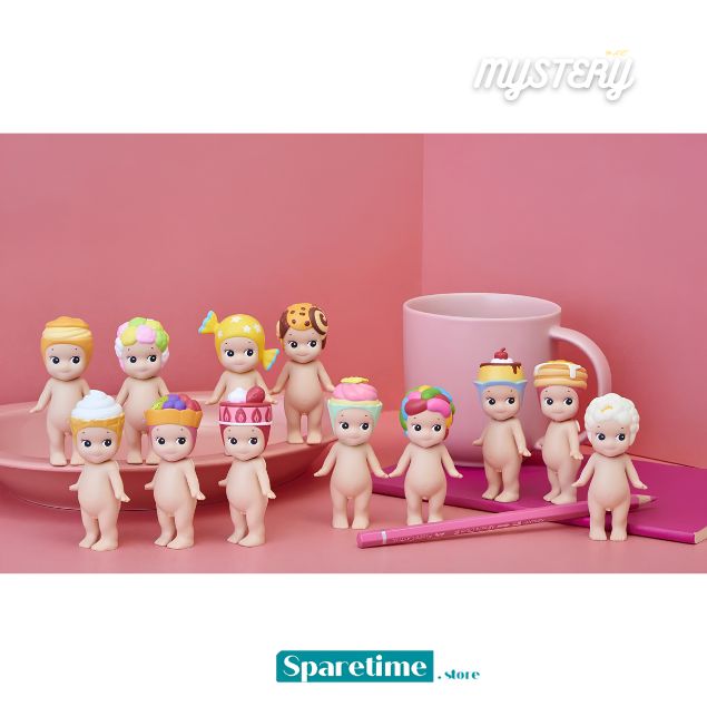 A group of small pastel figurines or dolls with colorful hats and accessories arranged on a pink surface in front of a pink backdrop, alongside a pink mug and pencil. The image includes 'mystery' text at the top right and 'Sparetime Store' branding at the bottom.