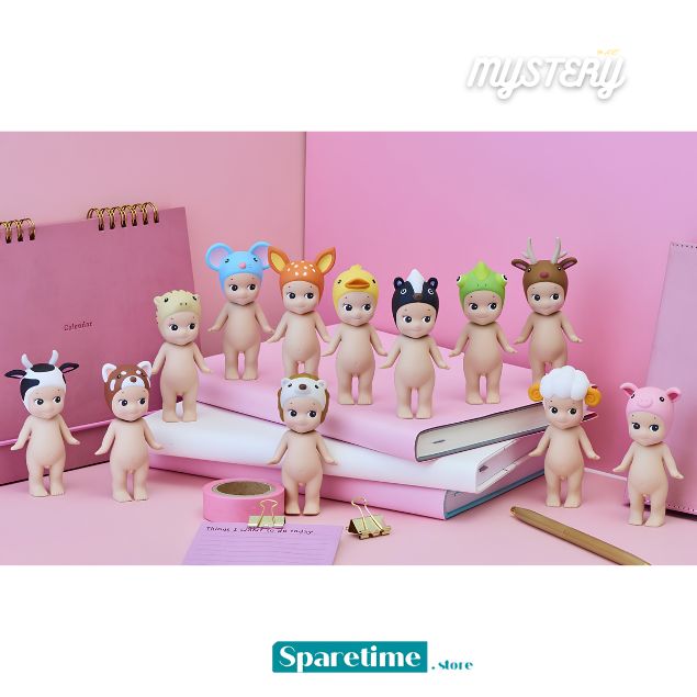 A group of small pastel-colored animal-themed figurines posed on pink notebooks and a pink surface against a pink backdrop. The figures have smooth skin and wear animal-inspired accessories such as antlers, horns, a cow print, and a pig print.
